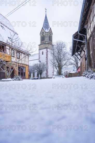 Historic church tower in a snowy village, quiet and rural winter atmosphere, Gechingen, Calw district, Germany