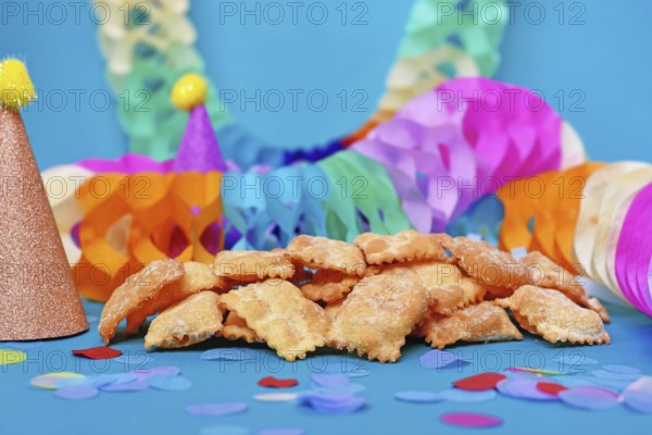 German pastries called 'Mutzen pastries or Muzenblätter' with powdered sugar on festive background. Traditional carnival and Fasching fried pastry