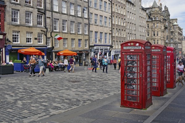 Red telephone boxes on a busy street in front of old buildings, Royal Mile, Edinburgh, Scotland, United Kingdom