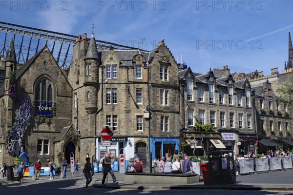 Historic buildings on a busy street with people and sunshine, Haymarket, Royal Mile, Edinburgh, Scotland, United Kingdom