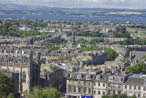 A panorama of buildings and water in a vast cityscape, view from Castle Hill, Edinburgh, Scotland, United Kingdom