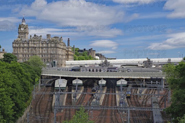 A train station with railroad tracks and an imposing building in the background, Waverley Station, Balmoral Hotel, Edinburgh, Scotland, Great Britain