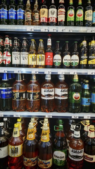 Shelves filled with various beverage bottles, beer selection in a Georgian supermarket, Tbilisi, Georgia