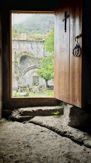 An open entrance to a monastery with a view of the old stone structure in the courtyard, Debed Canyon, Armenia