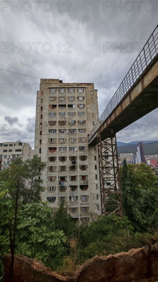 An old prefabricated building connected by a bridge with a grey sky, interesting building from a beautiful perspective, Tbilisi, Georgia