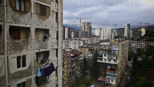 View of an urban landscape, residential district in Tbilisi with high-rise buildings and cranes, laundry hanging to dry on the balcony, Tbilisi, Georgia