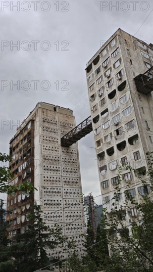High-rise concrete buildings connected by metal bridges under cloudy sky, nostalgic charm, architecturally interesting living silo, prefabricated buildings, Tbilisi, Georgia