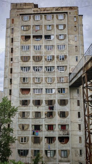 A large, old prefabricated high-rise building with distinctive round windows, interesting building in a residential area of Tbilisi, Georgia