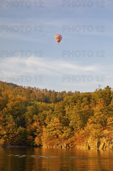 Hot air balloons over the Brno Reservoir (Brnenská prehrada) on the Svratka River on a sunny autumn day. The reservoir is located northwest of the city of Brno in the Czech Republic