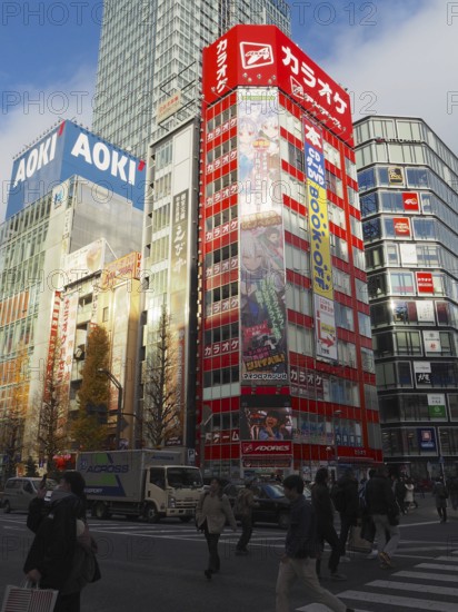 Bustling city street with tall buildings and colorful billboards in daylight, Akihabara Electric Town, Tokyo, Japan