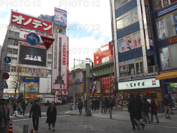Busy street intersection in a Japanese city with tall buildings and colorful billboards, Akihabara Electric Town, Tokyo, Japan