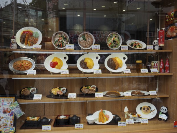 Restaurant window with various decorated food plates, Tokyo, Japan