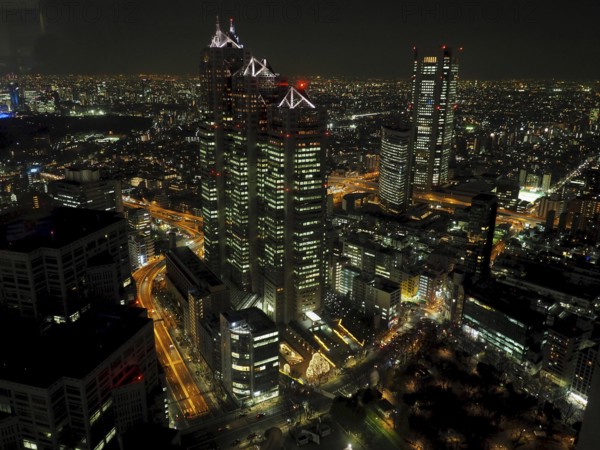Night scene of an impressive cityscape with illuminated skyscrapers and bustling streets, Tokyo, Japan
