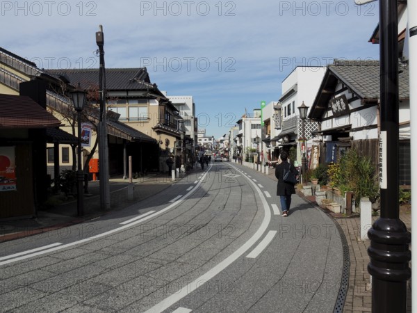 Empty street with traditional buildings and clear blue sky, Densha-michi street, Narita, Japan