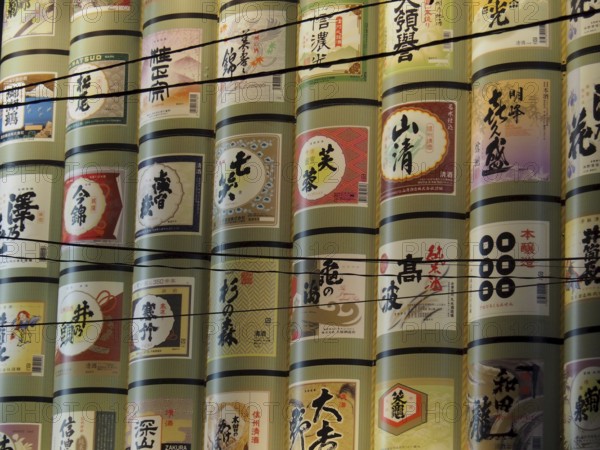 Tall stacks of decorative rice barrels with Japanese characters, Nagano, Japan