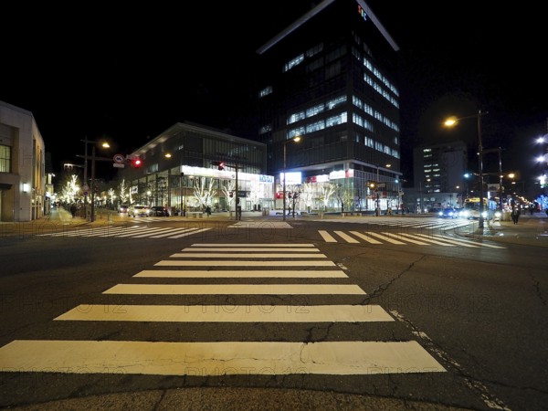 Modern buildings light up a nocturnal intersection full of lights, Chuo-dori Street, Nagano, Japan