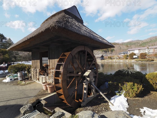 Small rustic house with big water wheel on a snowy day, Oshino Hakkai, Kawaguchiko, Japan