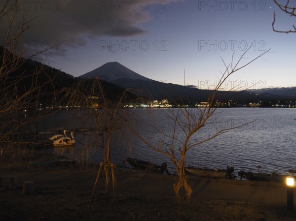 View of lake at night with Mount Fuji in the background and calm atmosphere, Lake Kawaguchiko, Japan