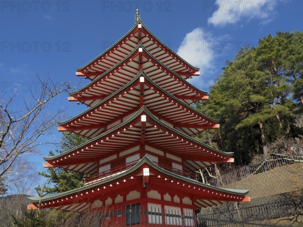 Chureito pagoda against blue sky surrounded by green trees, Kawaguchiko, Japan
