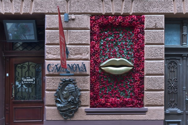 Bronze relief from Casanova, window with mouth and rose petals at Casanova restaurant, Lviv, Ukraine