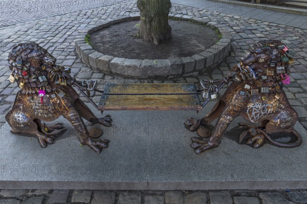 Lion figures with love locks holding a bench, Lviv, Ukraine