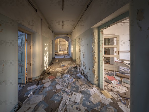 A room and corridor full of files lying around in an abandoned administration building, Lost Place, Saxony-Anhalt, Germany