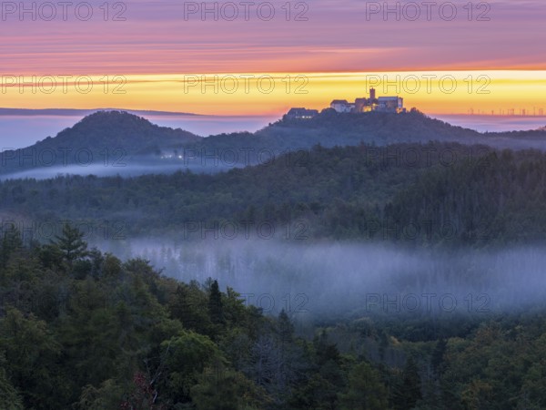 View from Rennsteig across the Thuringian Forest to Wartburg at dawn, morning fog in the valleys, near Eisenach, Thuringia, Germany