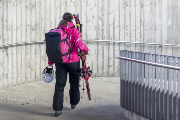 Woman with skiing equipment, Zweisimmen, Switzerland