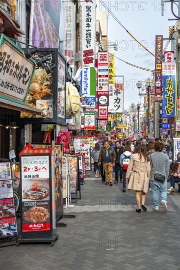 Lots of colorful signs in a pedestrian zone with shops and restaurants, Dotonbori, Osaka, Japan