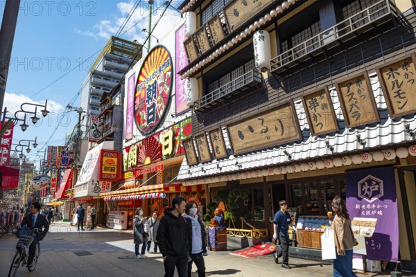 Lots of colorful signs in a pedestrian zone with shops and restaurants, Shinsekai, Osaka, Japan