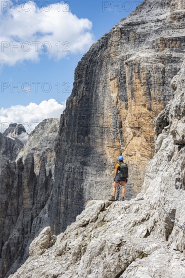 Hikers on the Sentiero Brentari via ferrata in front of cliffs, Brenta Mountains, Brenta-Adamello Natural Park, Trentino, Italy