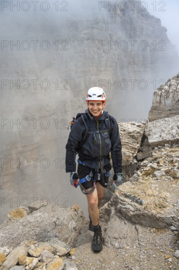 Happy mountaineer, Via Ferrata Oliva Detassis via ferrata in fog, rocky mountain peaks and mountain scenery, Brenta Mountains, Parco Naturale Brenta-Adamello, Trentino, Italy