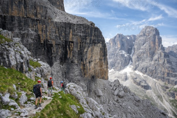 Three mountaineers on a hiking trail, rocky mountain landscape, Via Ferrata SOSAT via ferrata, Brenta Mountains, Trentino, Italy