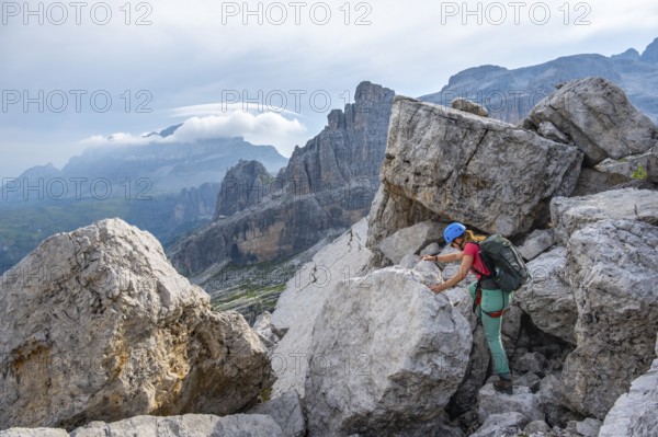 Female mountaineer on a hiking trail, rocky mountain landscape, Via Ferrata SOSAT via ferrata, Brenta Mountains, Trentino, Italy