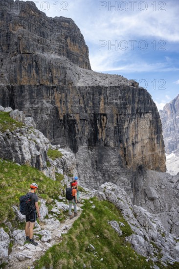 Three mountaineers on a hiking trail, rocky mountain landscape, Via Ferrata SOSAT via ferrata, Brenta Mountains, Trentino, Italy