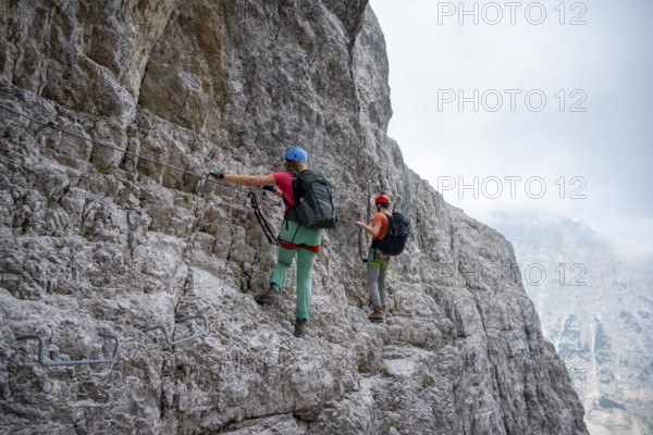 Two mountaineers climbing on rock face, rocky mountain landscape, Via Ferrata SOSAT via ferrata, Brenta Mountains, Trentino, Italy