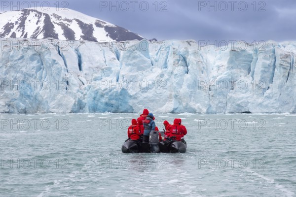 Boat with eco-tourists in front of Idabreen, Ida glacier calving into Liefdefjorden at Idabukta bay, Haakon VII Land, Spitsbergen, Svalbard, Norway