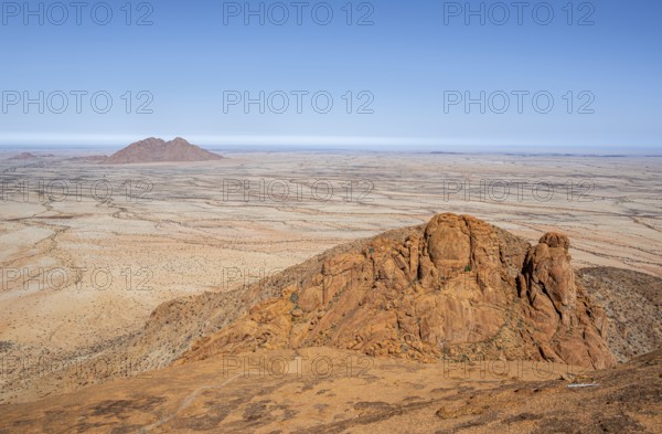 Red rocks against an endless desert landscape and blue sky in Spitzkoppe, Spitzkoppe, Namibia