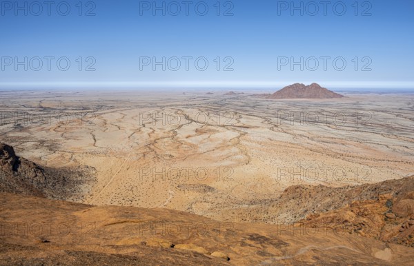 Wide desert landscape with rocky hills and bright blue sky in Spitzkoppe, Spitzkoppe, Namibia