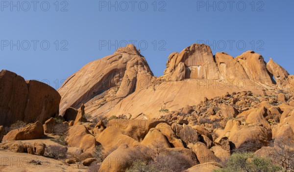 Monumental sandstone mountains rise into the clear desert sky, Spitzkoppe, Namibia