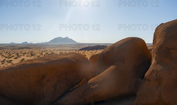 Sunny desert landscape with view of distant mountain range, Spitzkoppe, Namibia