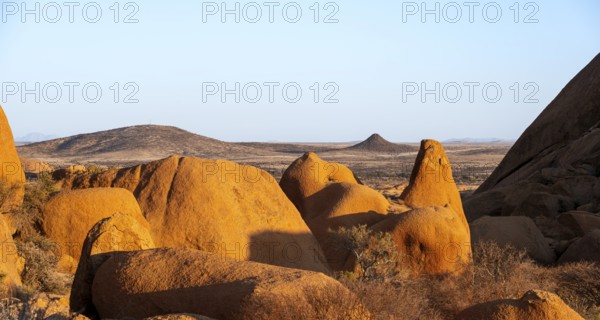 Extensive rock formations and barren desert landscape under clear skies in Spitzkoppe, Spitzkoppe, Namibia