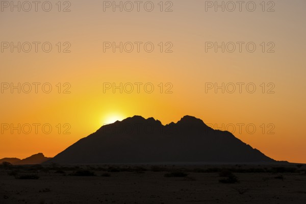 Sunset behind a distinctive mountain silhouette in the wilderness of Spitzkoppe, Spitzkoppe, Namibia