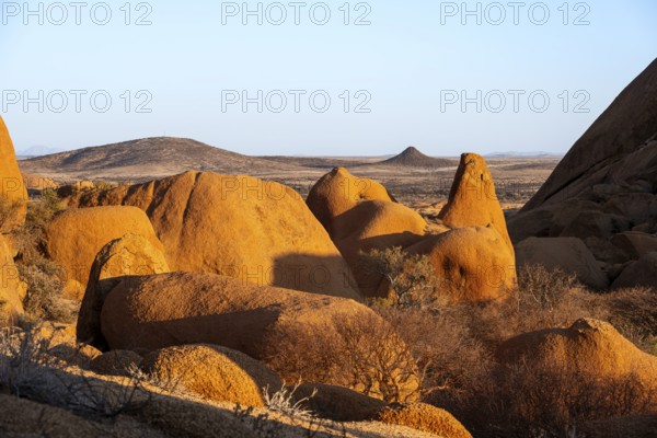 Rocks cast shadows over the dry landscape that stretches in the distance in the Spitzkoppe Desert, Spitzkoppe, Namibia