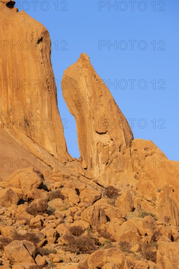Distinctive rock formations rise into the clear blue sky in the desert landscape of Spitzkoppe, Spitzkoppe, Namibia
