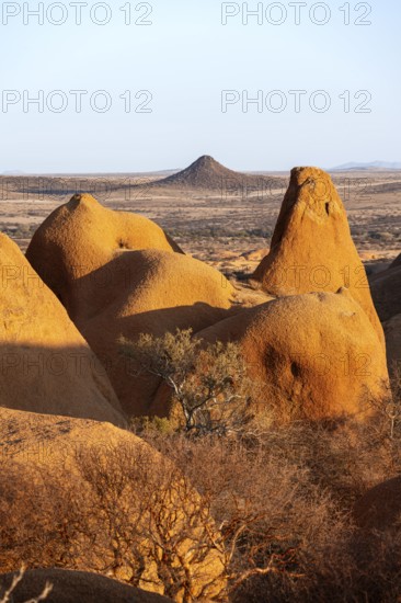 Sun-irradiated rocks offer views of the vast, barren landscape of the Spitzkoppe Desert, Spitzkoppe, Namibia