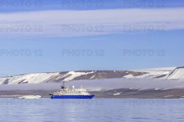 Antarctic cruise ship MV Sea Spirit of Poseidon Expeditions with eco-tourists cruising along the coast of Svalbard / Spitsbergen in summer