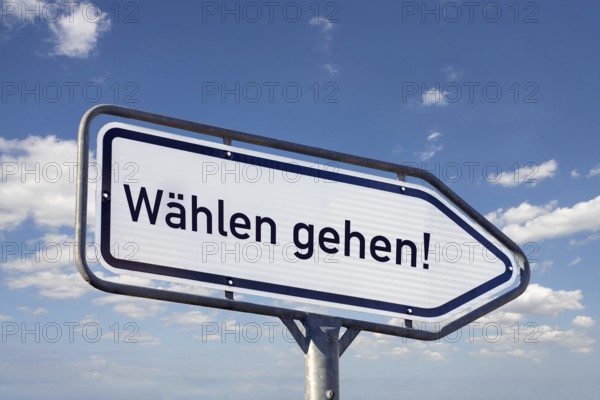 (Photomontage) Directional arrow with the inscription DIAL GO against a blue sky