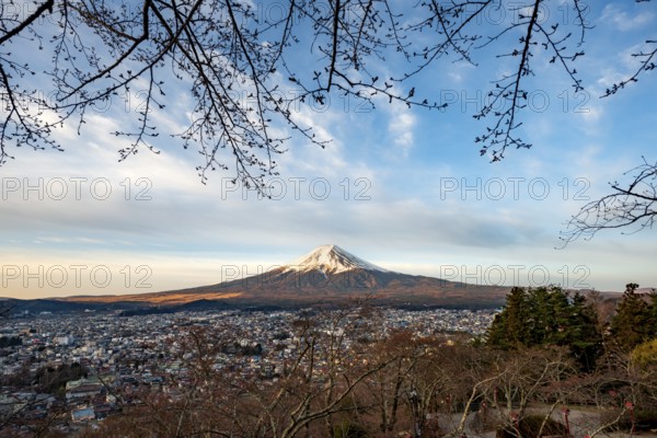 View of Mount Fuji volcano over Fujiyoshida City in morning light, at sunrise, Arakurayama Sengen Park, Yamanashi Prefecture, Japan