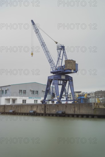 View of a crane standing directly at a harbor basin, Bremerhaven, Bremen, Germany